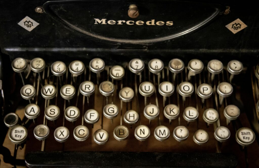 Close-up of an antique Mercedes typewriter keyboard with classic round keys showcases vintage technology.